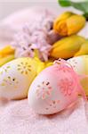 Yellow and pink flowery Easter eggs on pink background with hyacinth and tulips. Shallow dof
