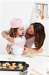 Attentive mother learning her daughter how to cook