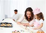 Mother and daughter cooking while dad relaxing on the sofa