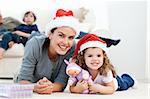 Happy mother and daugher at christmas lying on the floor at home