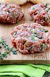 raw minced meat for hamburgers on a wooden board