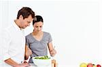 Active couple preparing a salad for lunch in the kitchen