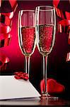 Two full glasses of champagne over red background