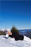 Female snowboarder is sleeping on snowboard