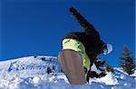 Male snowboarder is balancing on his board in mountains