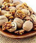 whole and chopped walnuts on a brown background