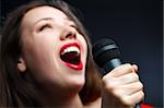 Woman sing over dark background. focused on hand.