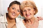 A beautiful portrait of grandma and grandaughter smiling over white background