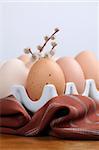 Brown chicken eggs in an egg holder and catkins. Shallow dof
