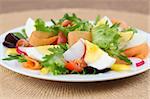 Mixed greens with eggs, cherry tomatoes, radish, carrot and yellow bell pepper. Shallow DOF