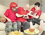 American football fans- father and sons - fighting for the television remote control.