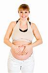 Smiling pregnant woman making heart with her hands on tummy isolated on white