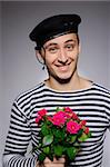Funny emotional romantic sailor man holding rose flowers prepared for a date