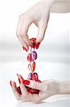Beautiful hands with healthy skin and perfect red manicure and pink necklace as decoration