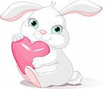 Small lovely rabbit holds love heart