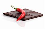 Red chili pepper and dark chocolate on white background. Shallow dof