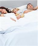 Cute little boy sleeping with his parents in the morning