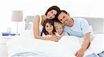 Happy children with their parents on the bed at home