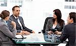 Charismatic businessman talking to his partners during a meeting at work