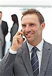 Successful businessman on the phone during a meeting with his team