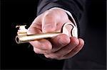 A businessman holding a golden key