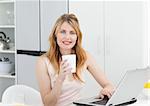 Woman drinking coffee in her kitchen at home