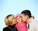 A picture of parents kissing their little girl over blue sky, a lot of space for text