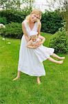 Young mother and daughter playing in meadow