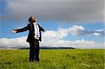 Relaxation businessman standing on the meadow
