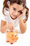 Little girl lying on floor and inserting a one euro coin on the piggy-bank