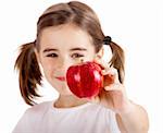 Healthy little girl holding and showing a red apple