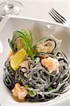 fresh seafood black squid ink coulored spaghetti pasta tipycal italian food