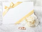 Wedding rings and wedding invitation with bow