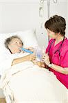 Nurse gives respiratory therapy to a patient recovering in the hospital.