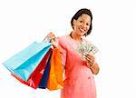 Beautiful African-american woman holding shopping bags and money.  Isolated on white.