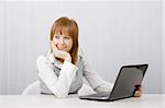Attractive relaxed and smiling girl with a laptop in the office