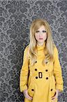 fashion retro blond woman yellow gabardine coat dark wallpaper