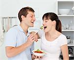 Happy couple eating together in the kitchen