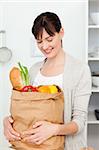 Woman with shoping bags in the kitchen at home