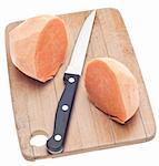 Sliced Sweet Potatoes on a Wooden Chopping Block Isolated on White with a Clipping Path.