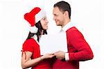 side view of young couple in red christmas clothes holding a white cardboard in hands