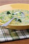 Healthy broccoli soup with potatoes on yellow plate