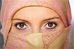 A portrait of an arabic woman face hidden behind a beautiful scarf