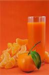 glass of tangerine juice on an orange background