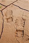 Boot footprints in dry cracked earth