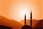 Vector mosque silhouette at sunset, with mountains on background