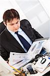 Serious business man sitting at office desk and working  with financial documents