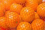 tangerines in red plastic net. fruit background