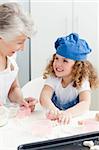 A little girl baking with her grandmother at home