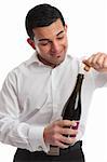 A man or waiter removes a cork from a bottle ready for a celebration.  White background.